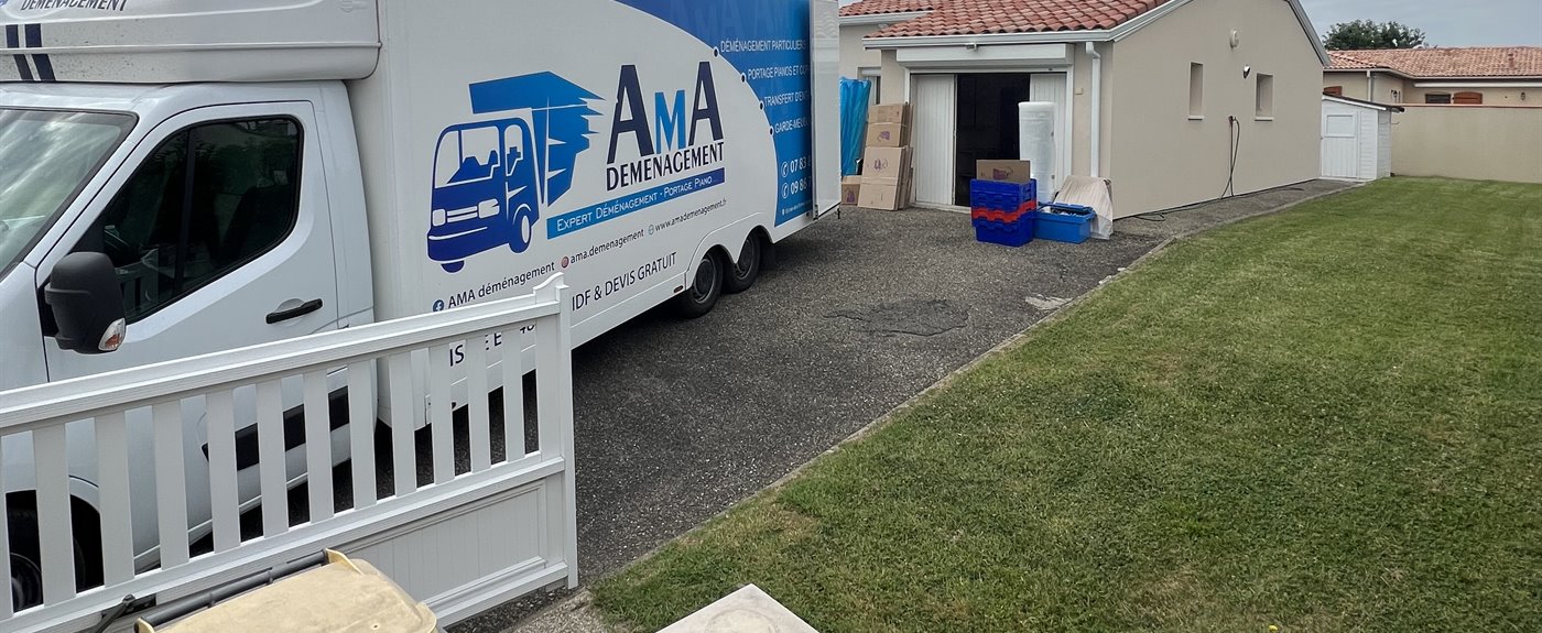 Camion AMA Déménagement stationné devant une maison, hayon ouvert pour le chargement